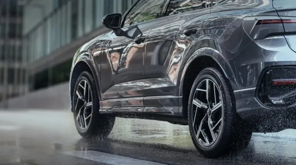 Сірий кросовер їде мокрою міською дорогою