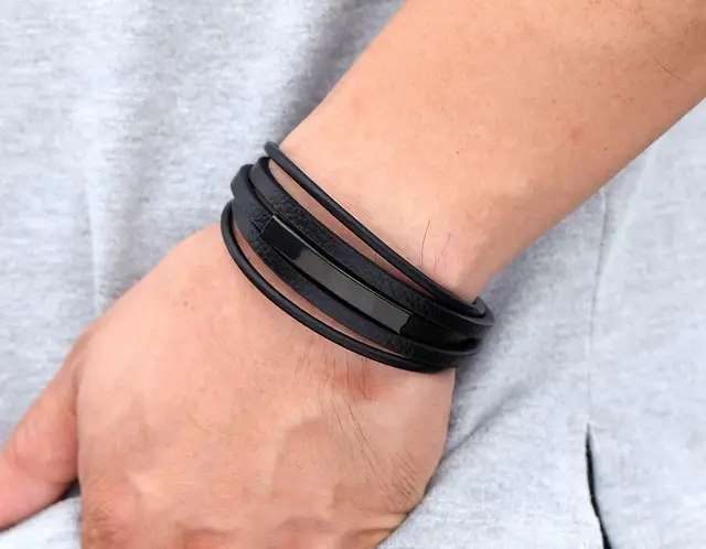 Чорний шкіряний браслет на зап’ясті чоловіка