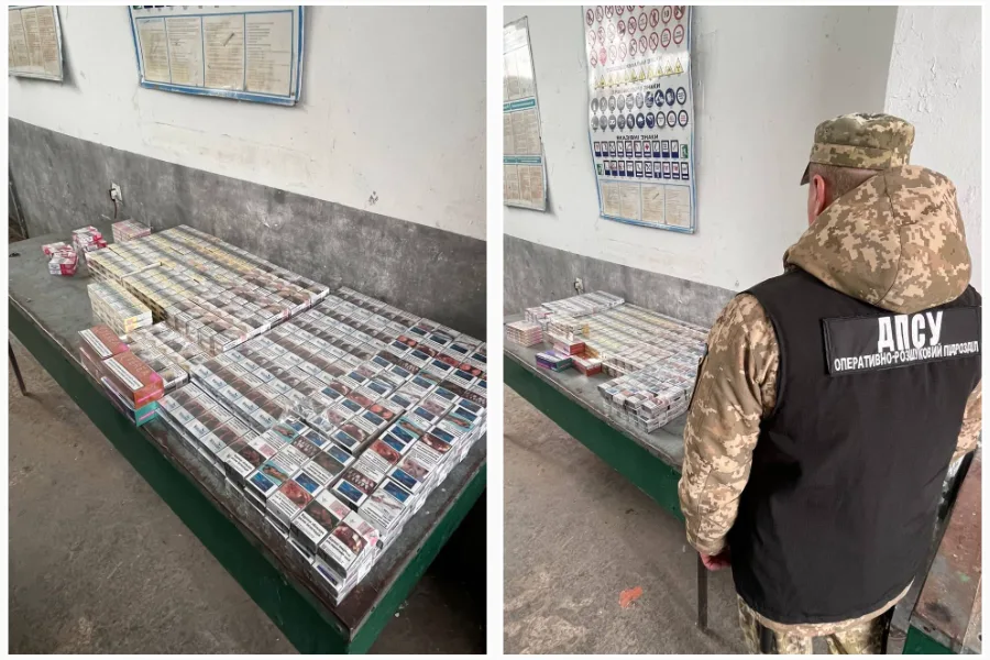 Військовий оглядає вилучені блоки сигарет на столі