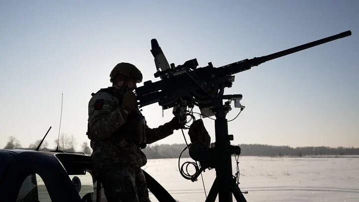 Військовий керує великокаліберною кулеметною установкою на полі