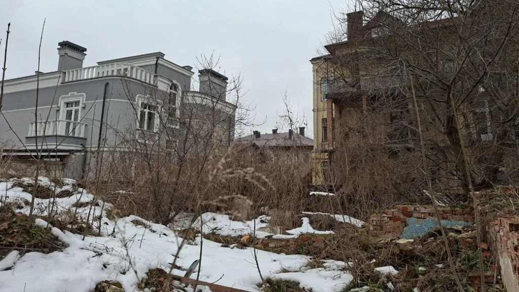 Занедбана ділянка між старими будинками взимку