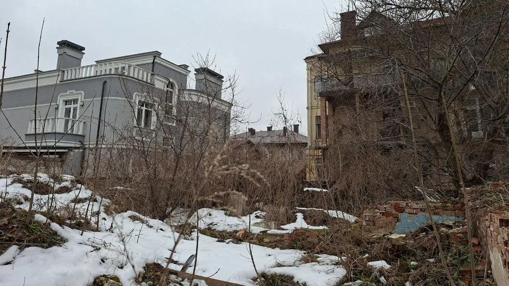 Занедбана ділянка між старими будинками взимку