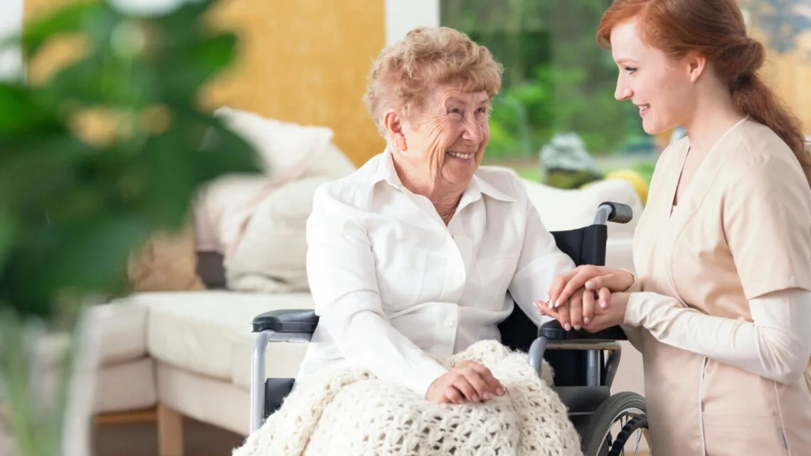 Доглядальниця допомагає літній жінці у візку