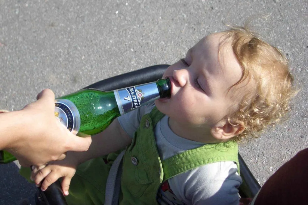 Дитина торкається пляшки з напоєм