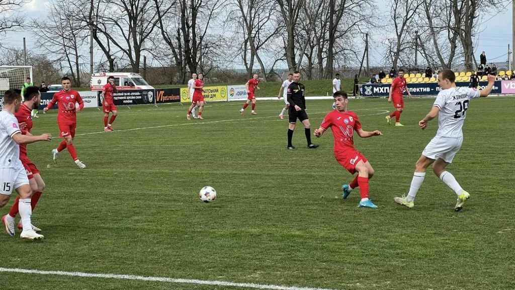 Футбольний матч між командами у червоній і білий формі