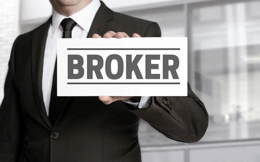 Брокер тримає табличку з написом BROKER