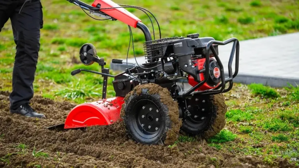 Мотоблок обробляє ґрунт на городі