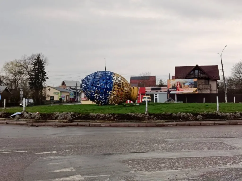 Впала новорічна прикраса на газоні біля дороги