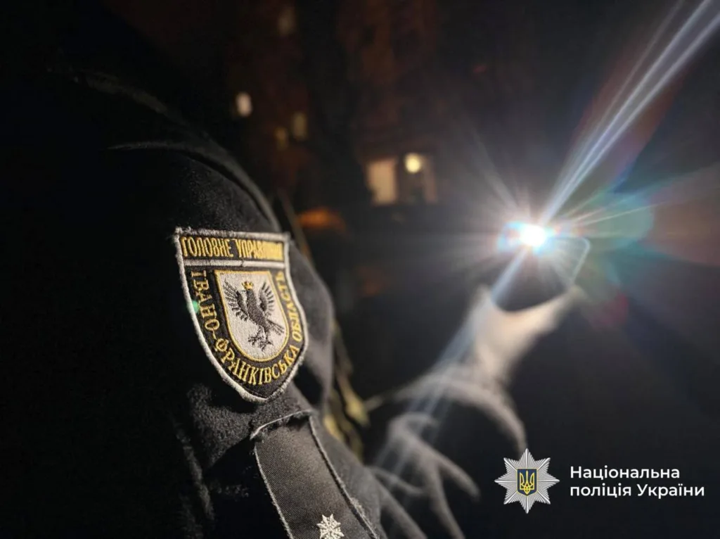 Поліцейський Івано-Франківщини з ліхтариком уночі