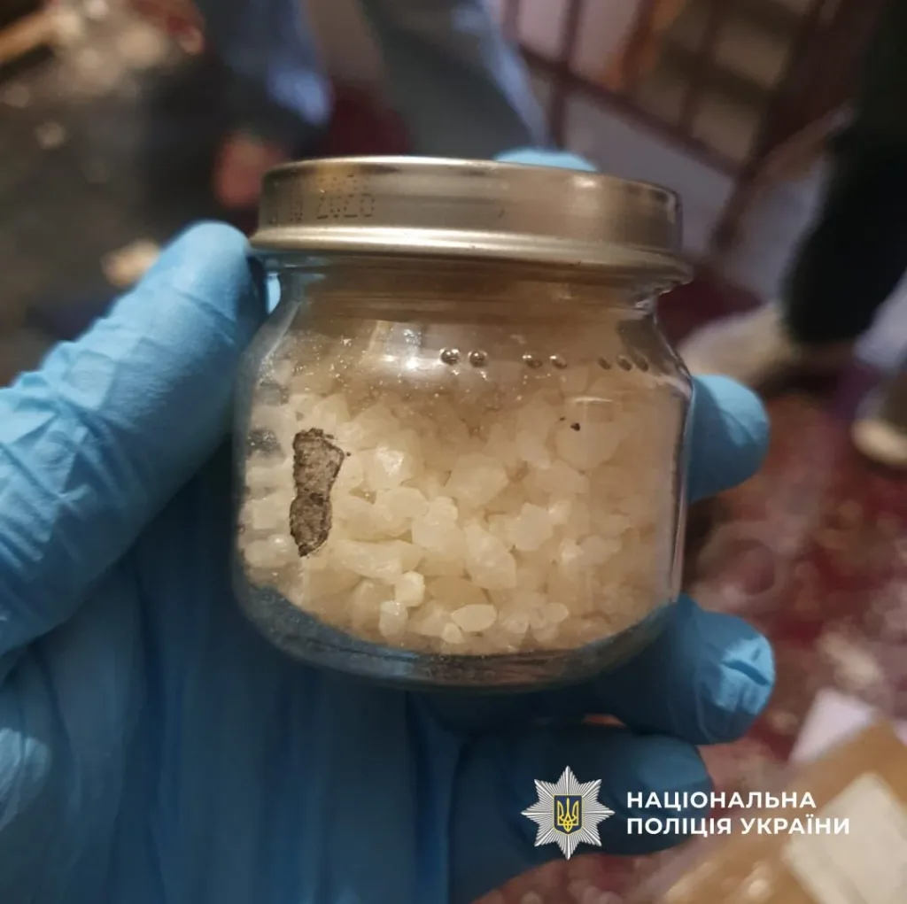 Банка з кристалічною речовиною в рукавичці