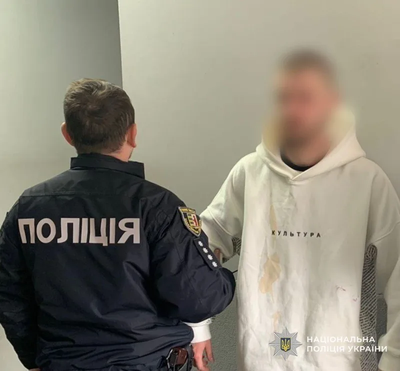 Поліцейський спілкується з чоловіком у білій худі