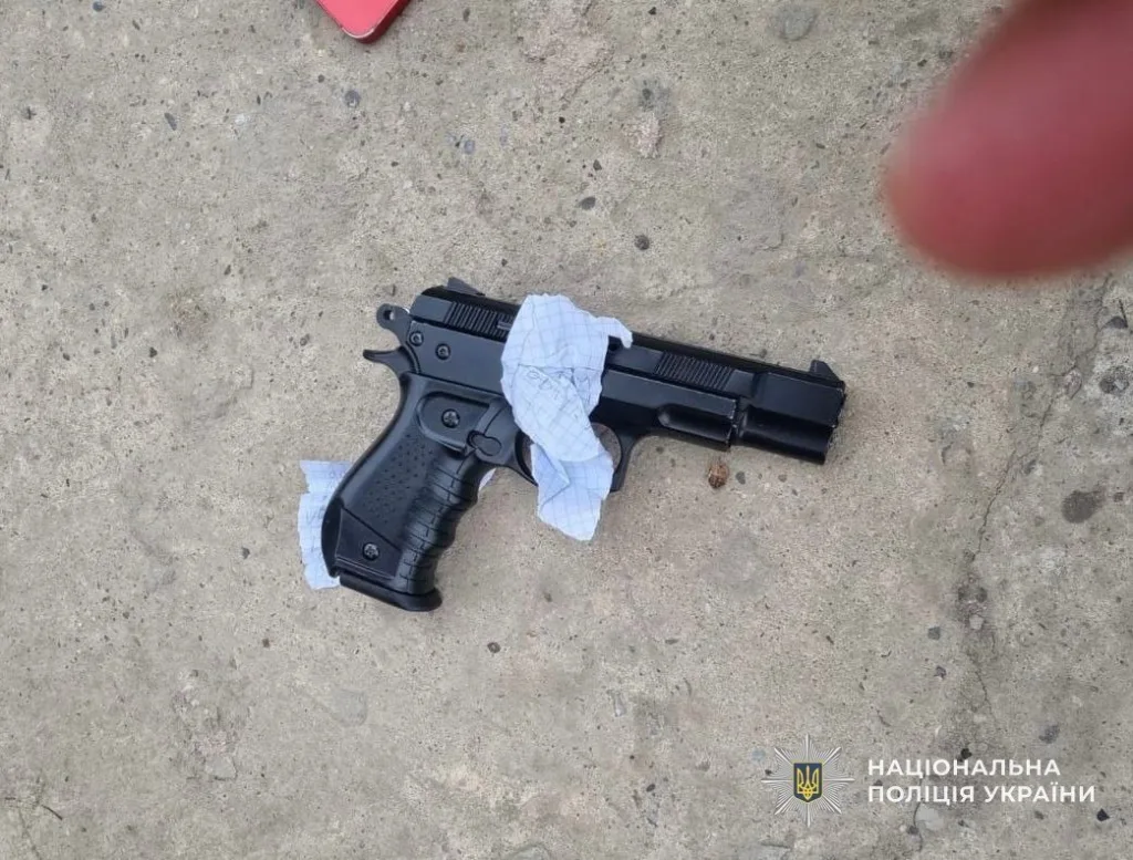 Пістолет на асфальті поруч із серветкою