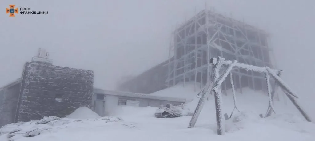 Засніжена будівля в горах у тумані
