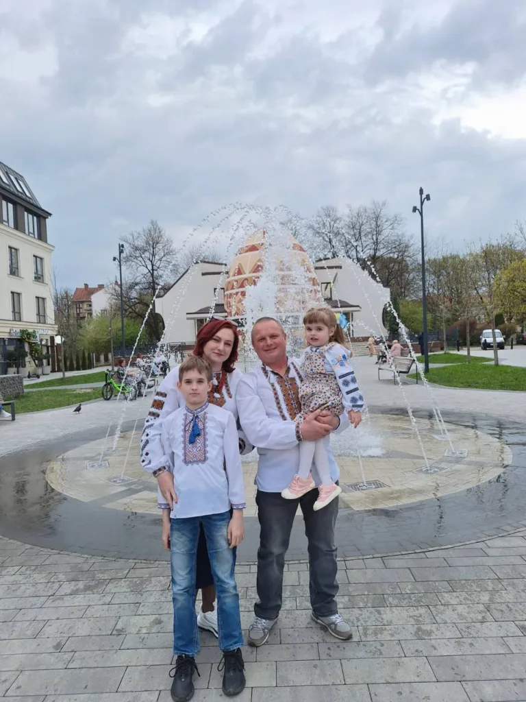 Сім'я у вишиванках біля фонтану з писанкою