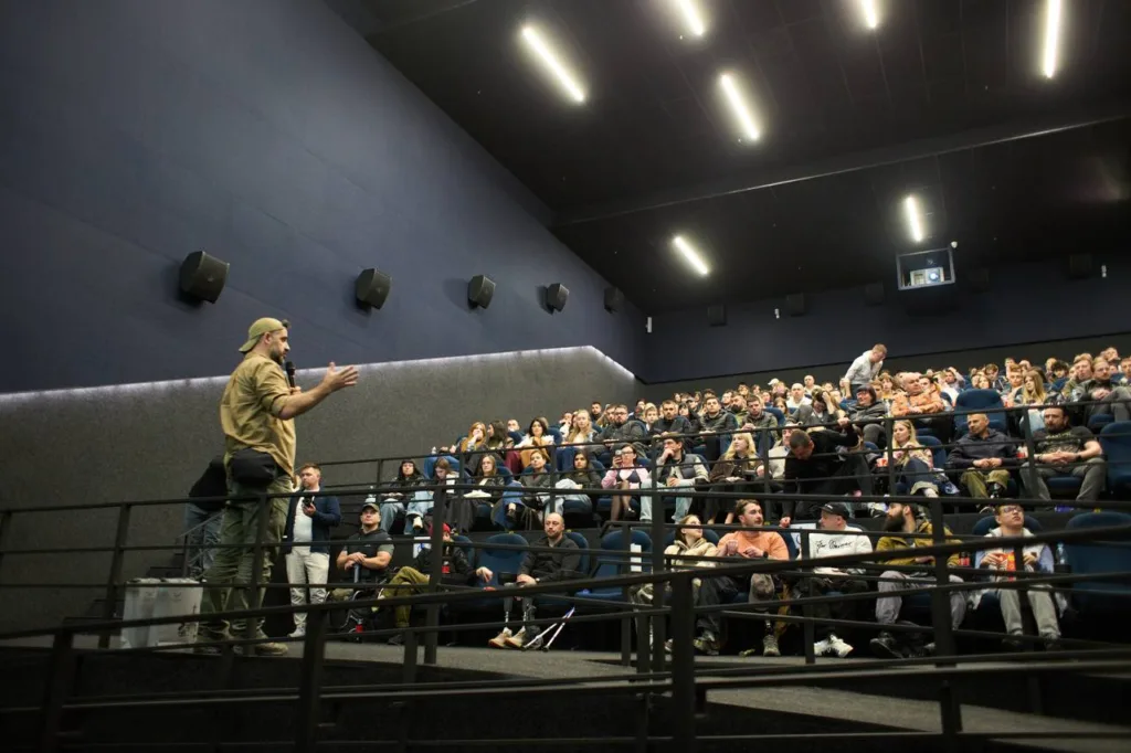 Лектор виступає перед аудиторією в кінотеатрі