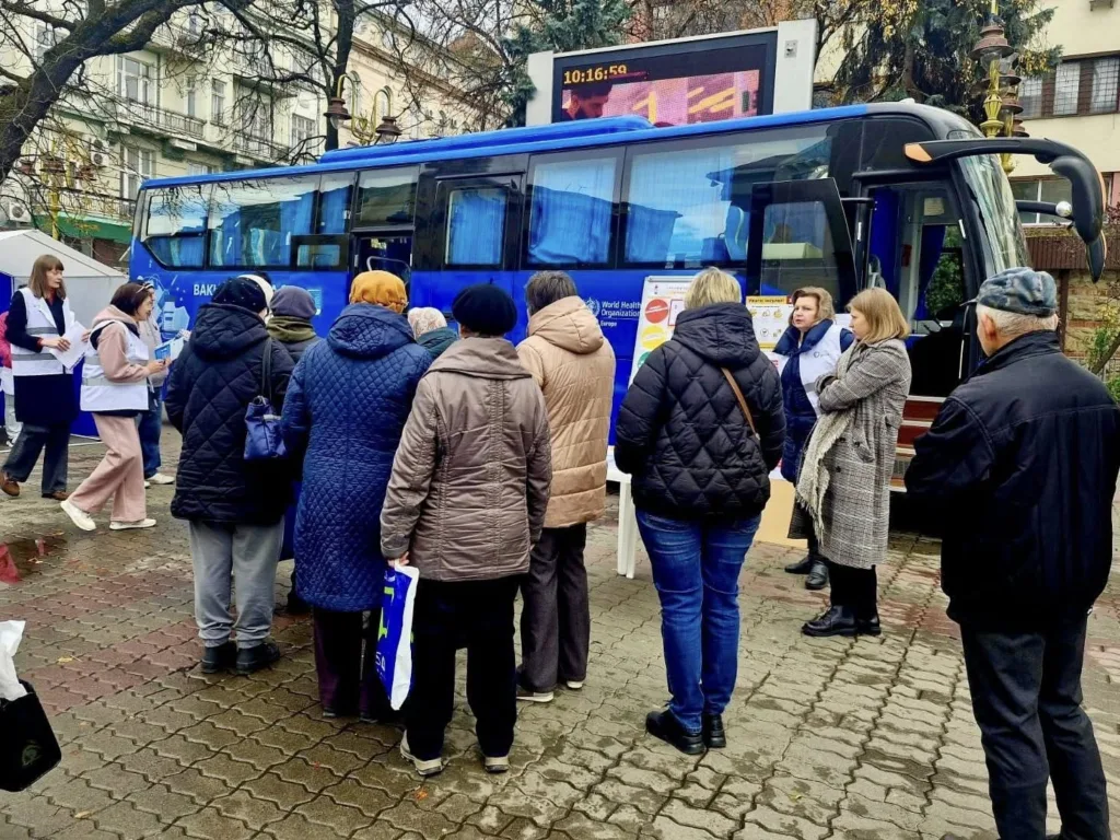 Люди біля мобільного пункту вакцинації на вулиці