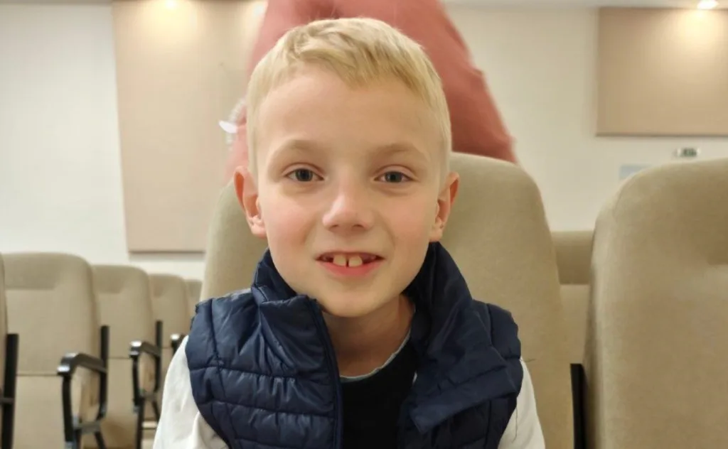 Хлопчик сидить у залі на стільці