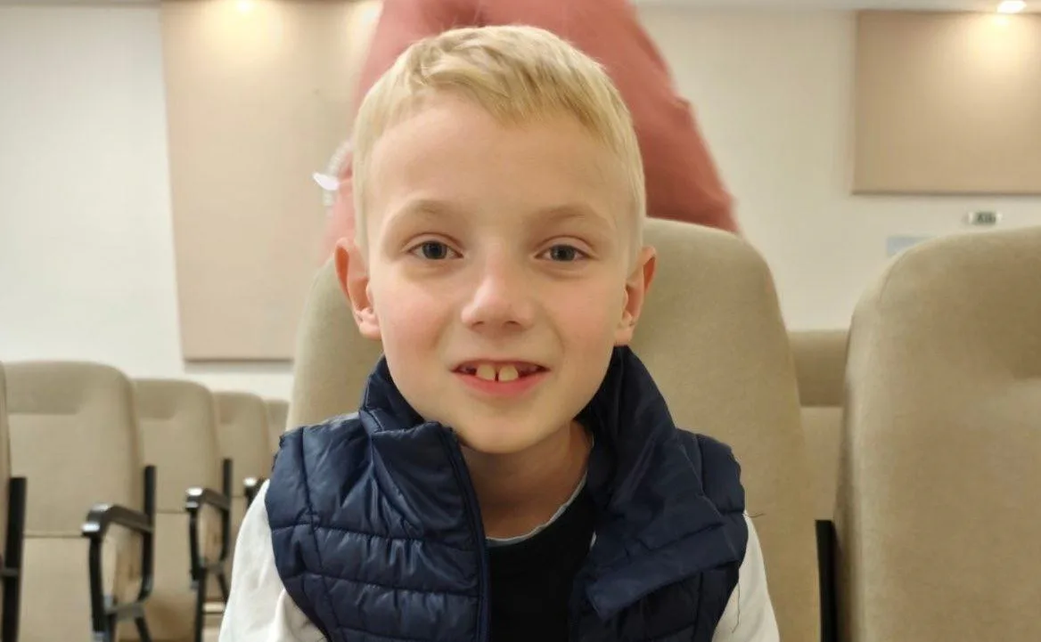 Хлопчик сидить у залі на стільці