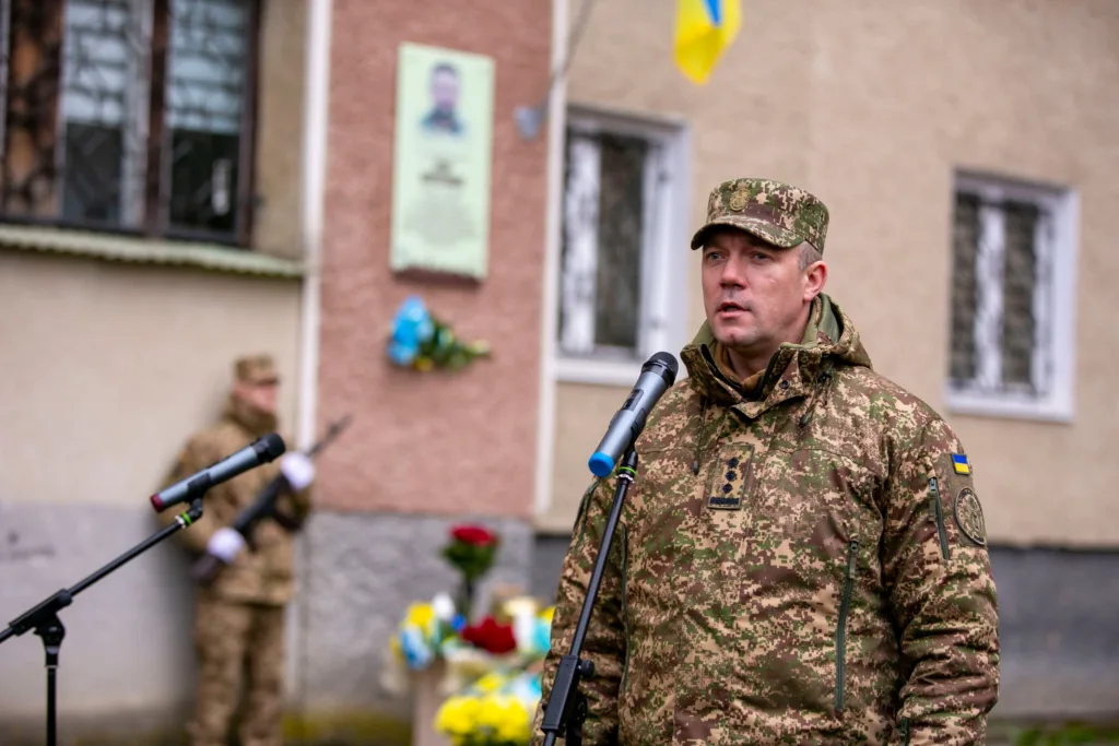 Військовий виступає біля меморіальної дошки