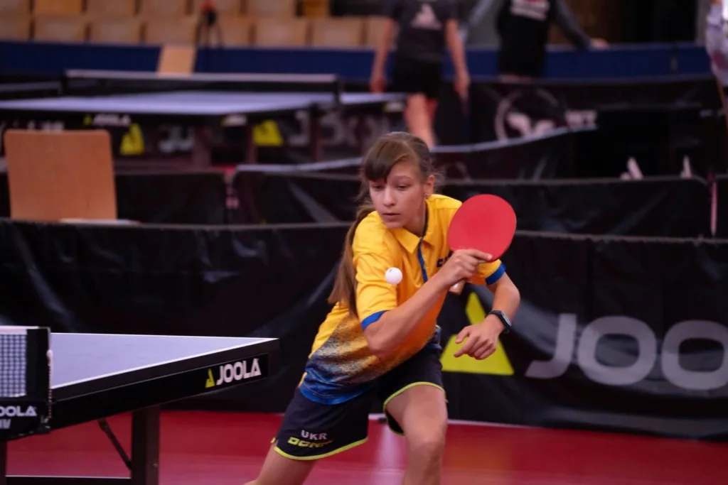 Дівчина грає в настільний теніс під час змагань