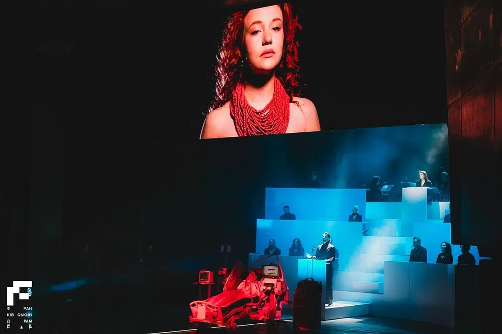 Театральна сцена з актором і великим екраном