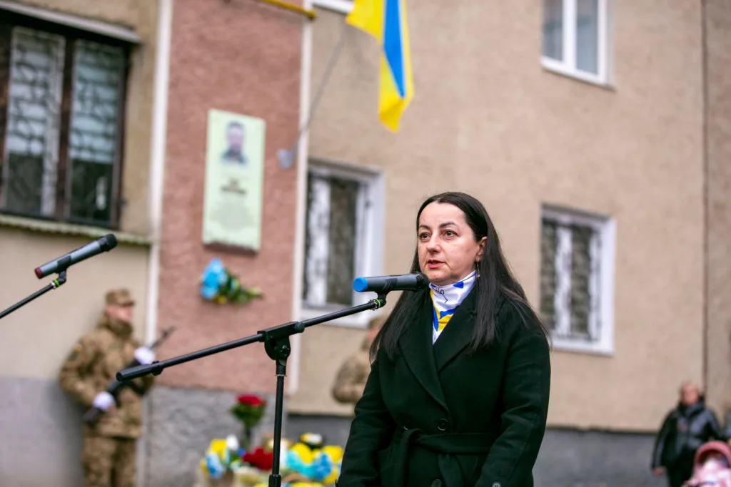 Жінка виступає на вулиці біля мікрофона