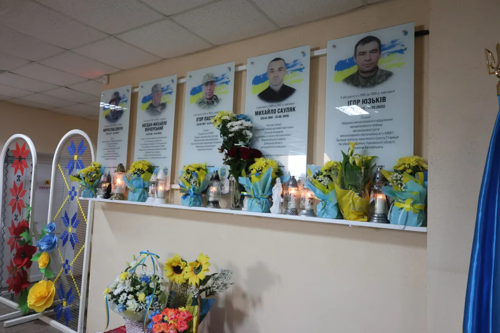 Меморіальна дошка загиблим військовим з квітами та свічками