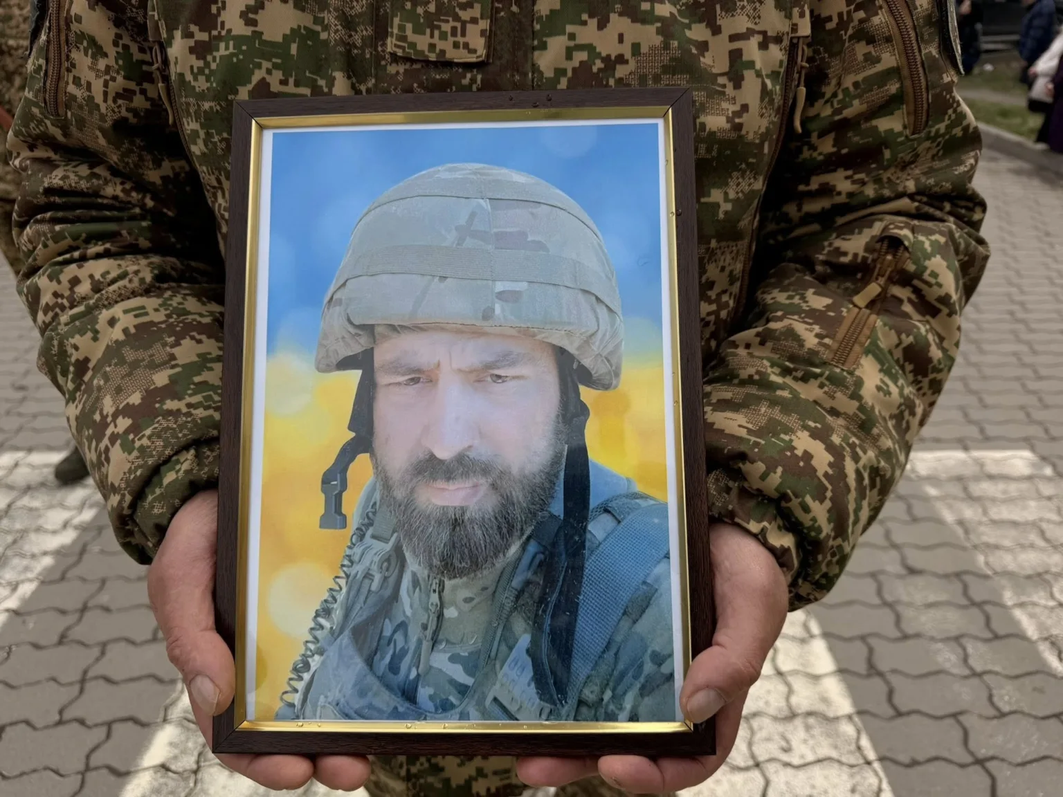 Військовий тримає фото солдата у рамці