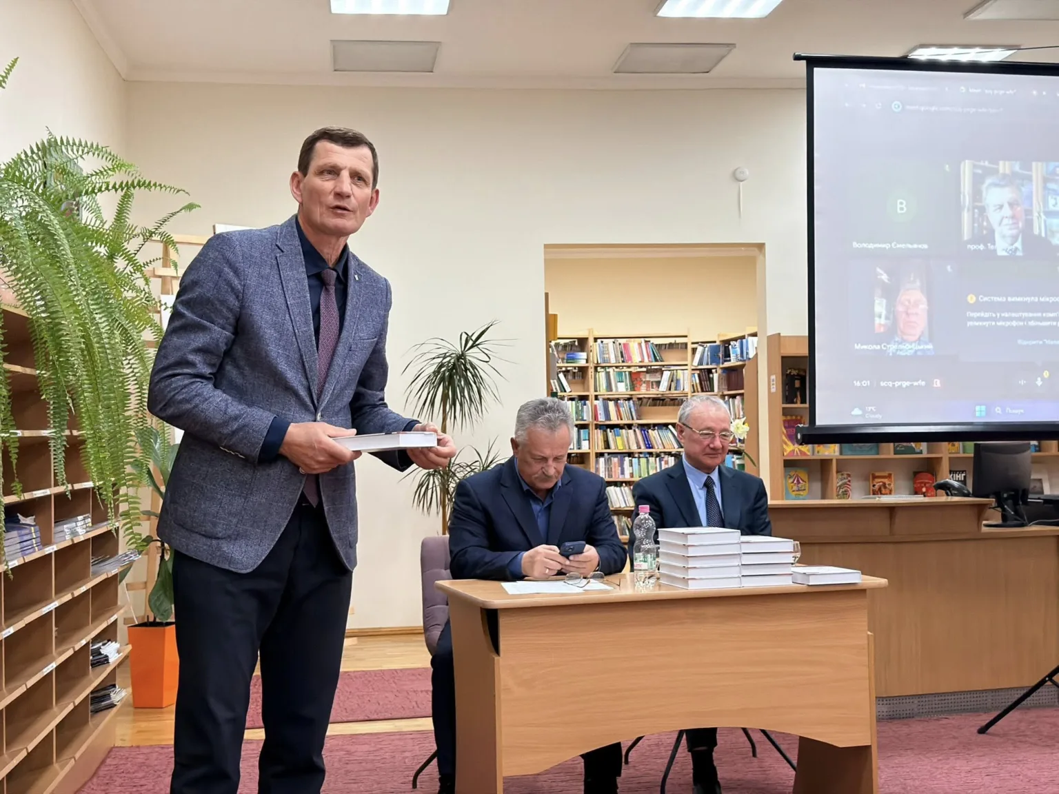 Презентація книги в бібліотеці з учасниками та екраном