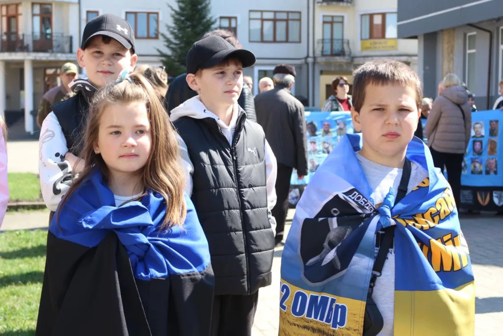 Діти з українськими прапорами на вулиці міста