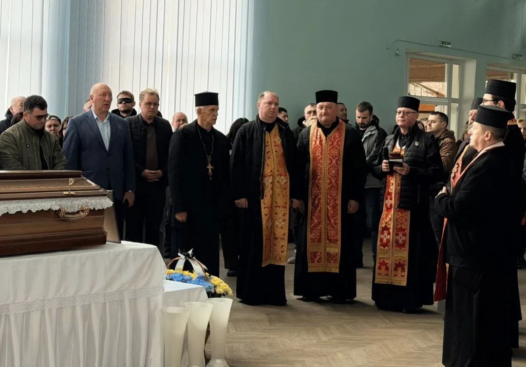 Священники та люди на похоронній церемонії