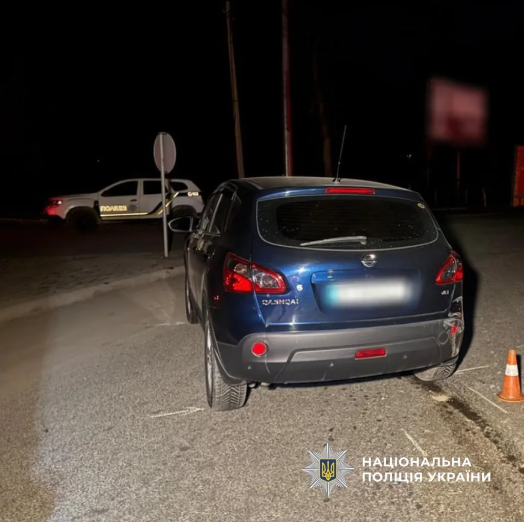 Поліція оглядає автомобіль на місці події вночі