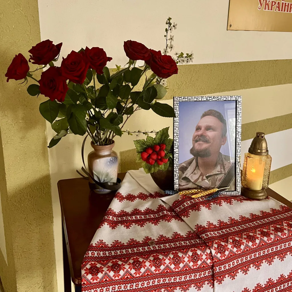 Меморіальний стіл із фото, квітами та свічкою