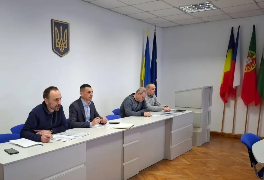 Засідання чиновників у залі з прапорами