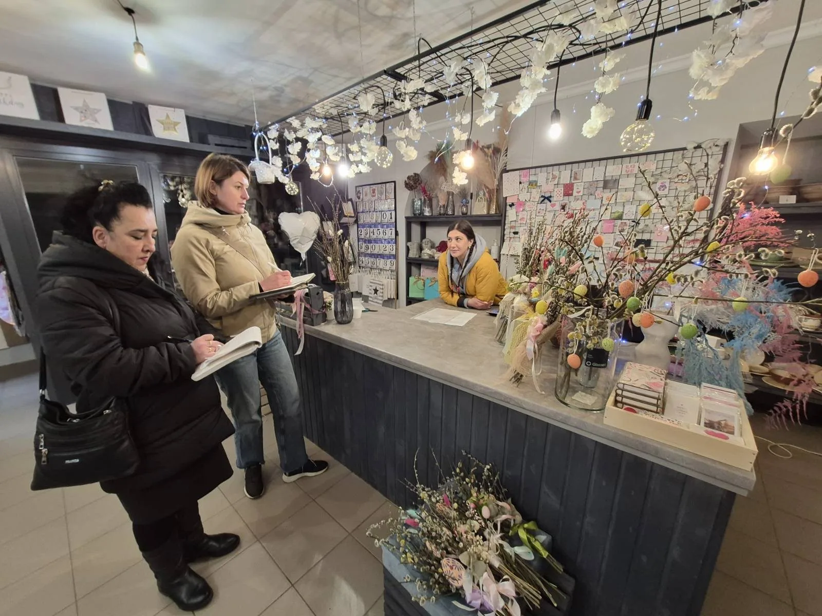 Жінки у квітковій крамниці спілкуються біля прилавку