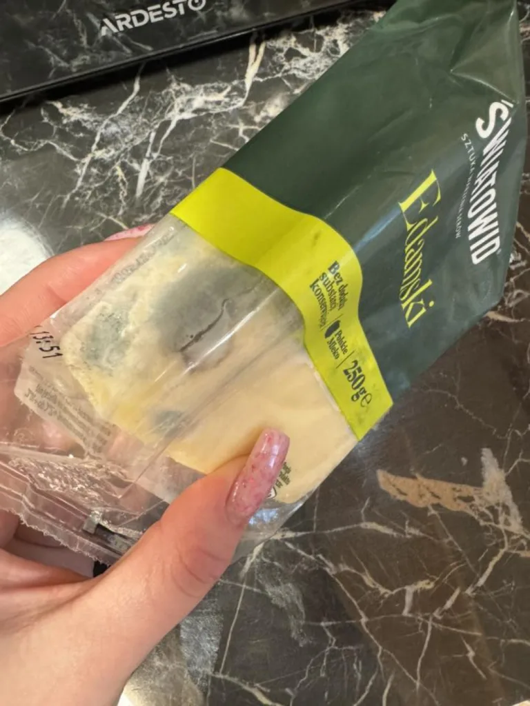 Пакет сиру Едамський у руці