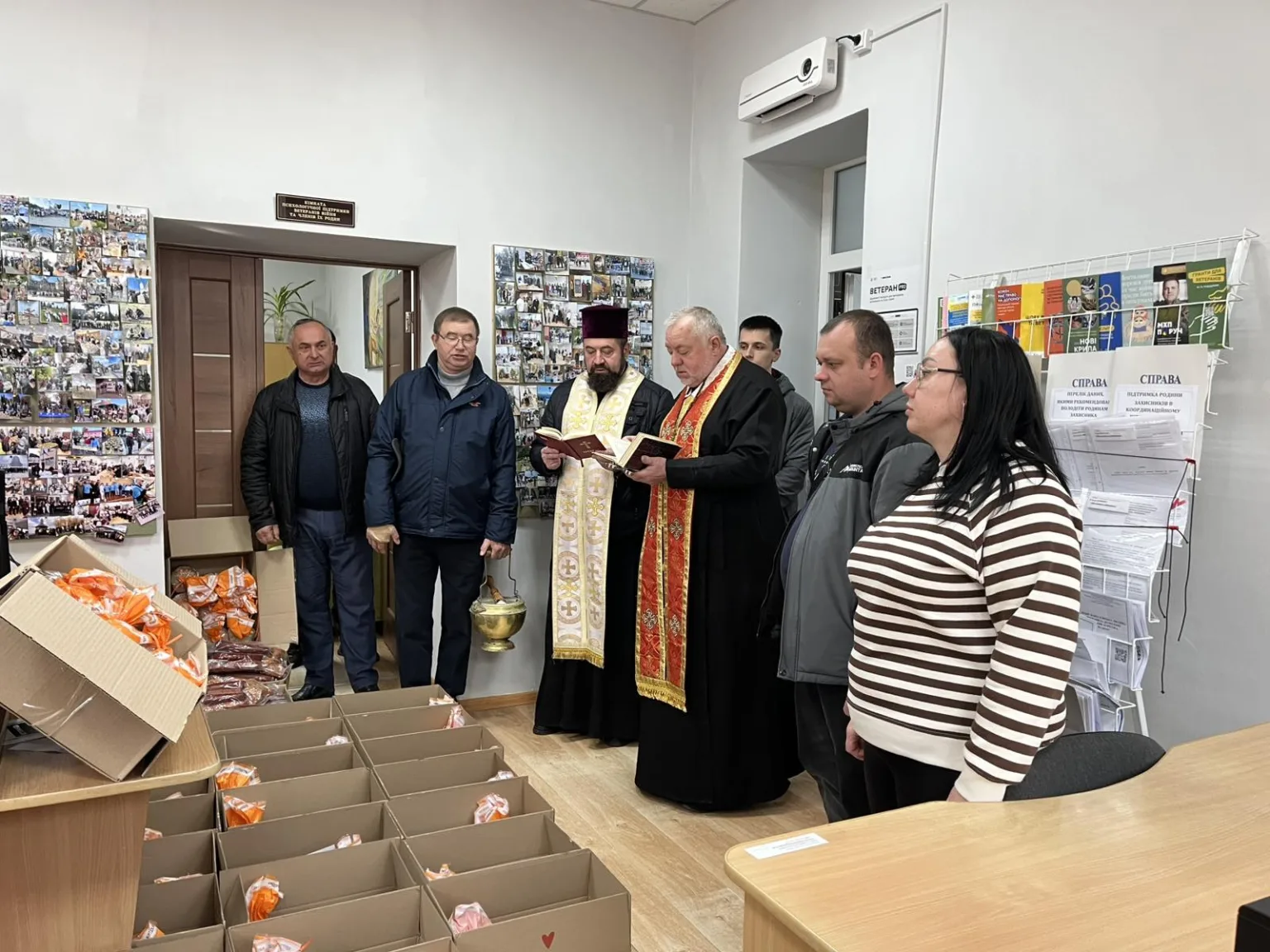 Священник благословляє гуманітарну допомогу у приміщенні