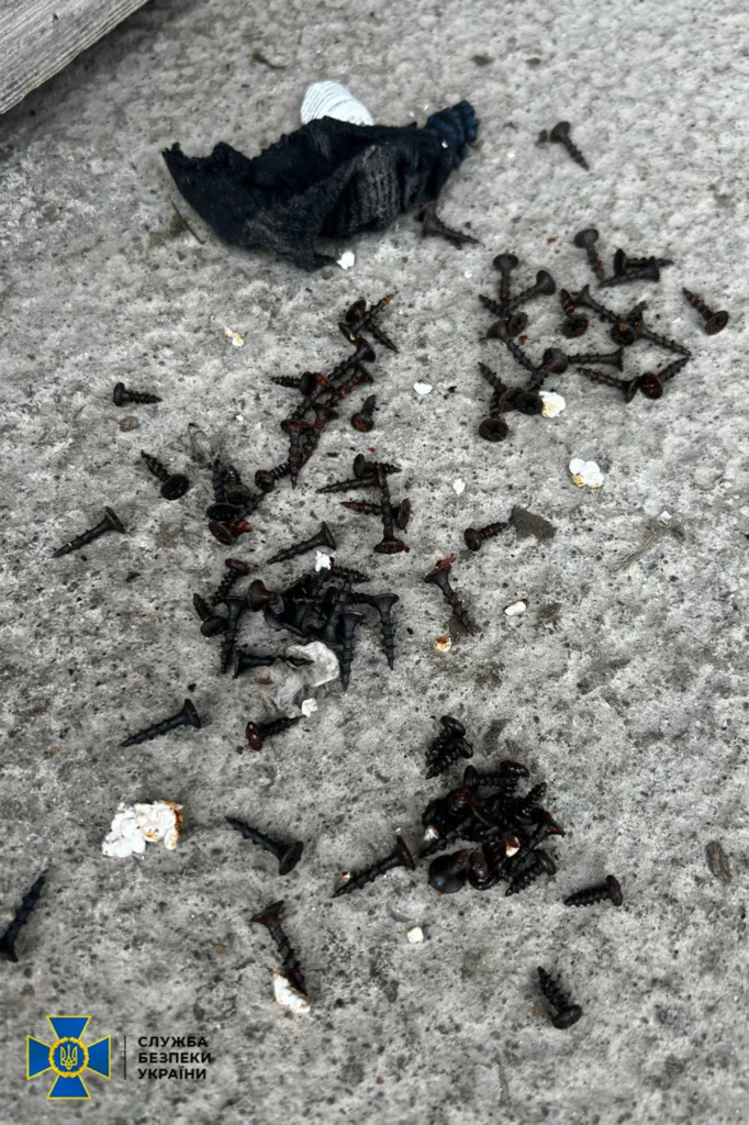 Розсипані чорні гвинти на бетонній поверхні