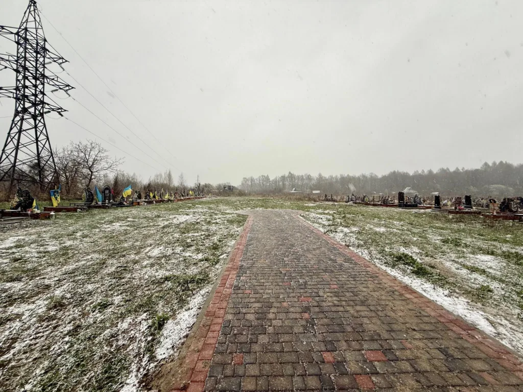 Кладовище з українськими прапорами вздовж зимової доріжки