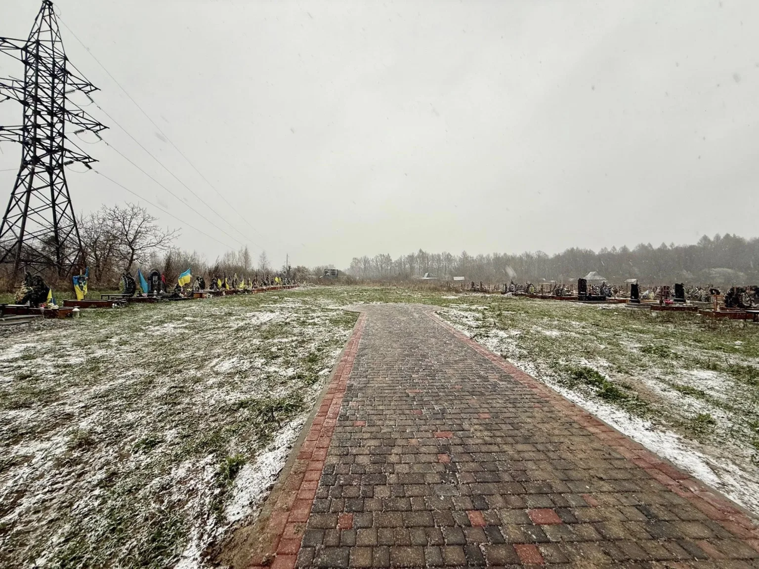 Кладовище з українськими прапорами вздовж зимової доріжки