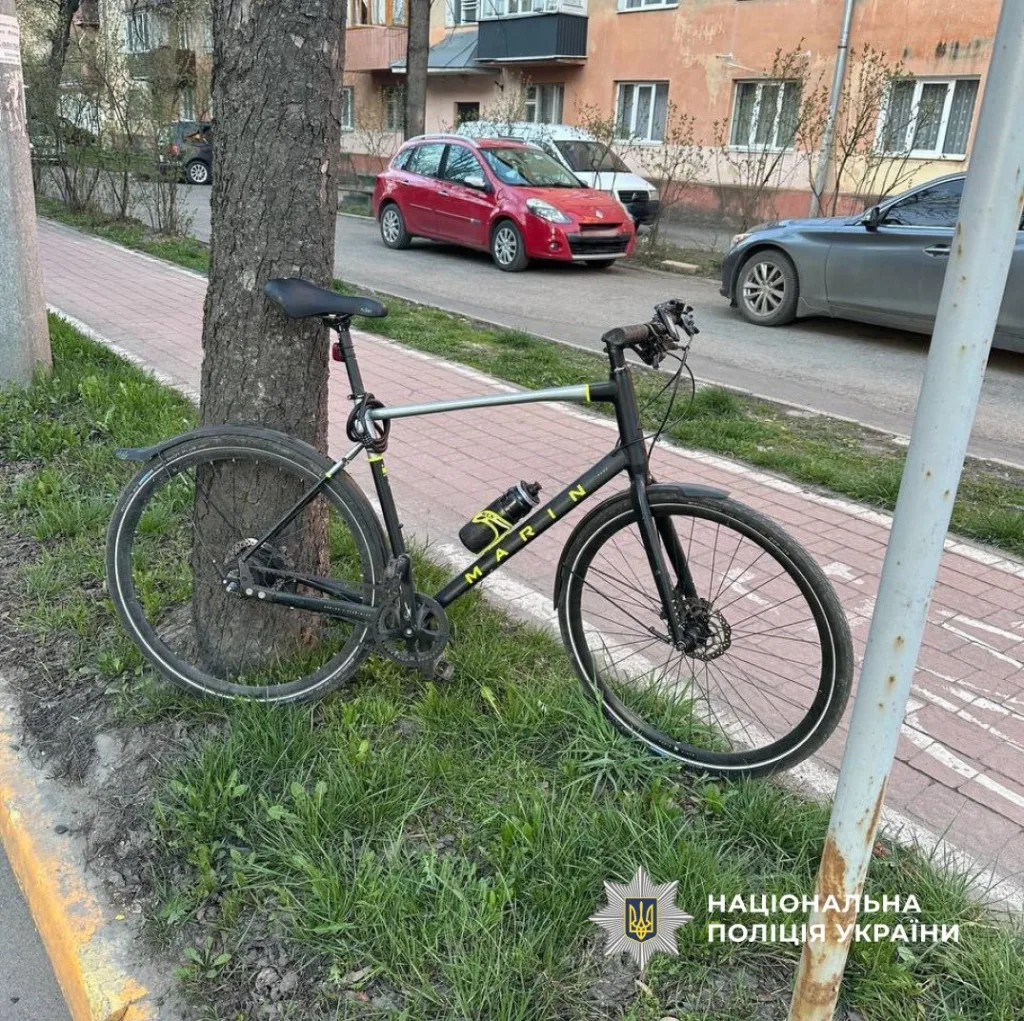 Чорний велосипед припаркований біля дерева на вулиці