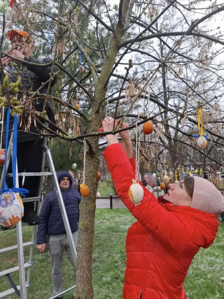 Люди вішають писанки на дерево у парку