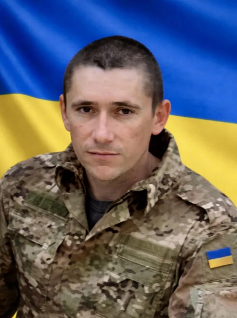 Український військовий на тлі прапора України