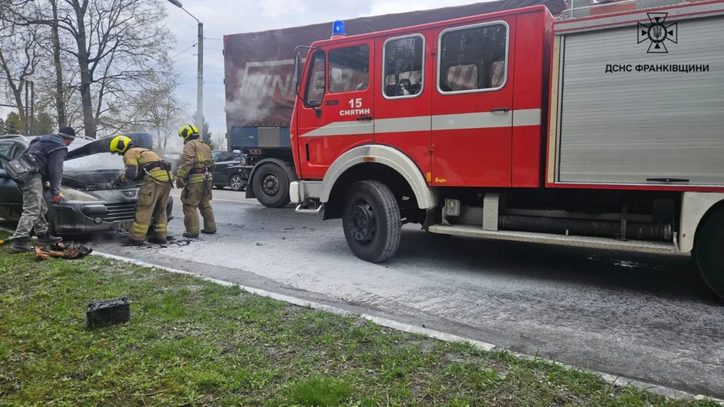 Пожежники гасять загорілий автомобіль біля пожежної машини