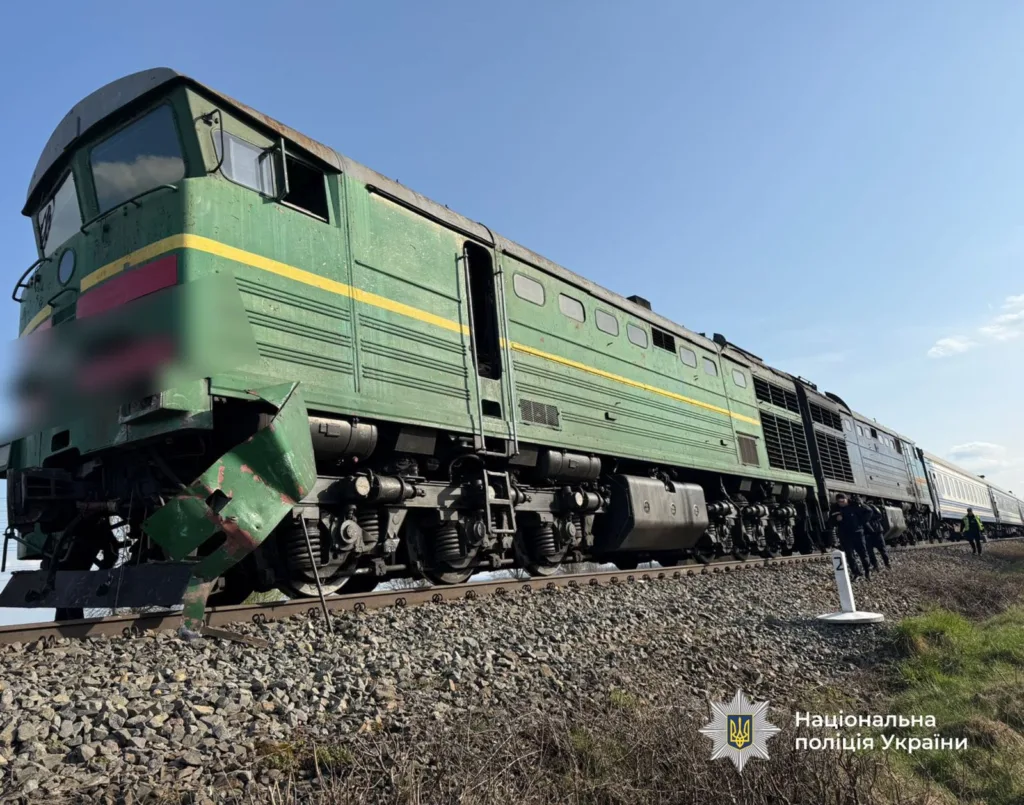 Пошкоджений зелений потяг на залізничній колії