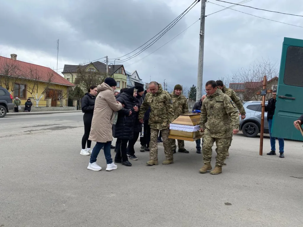 Військові несуть труну на похороні героя