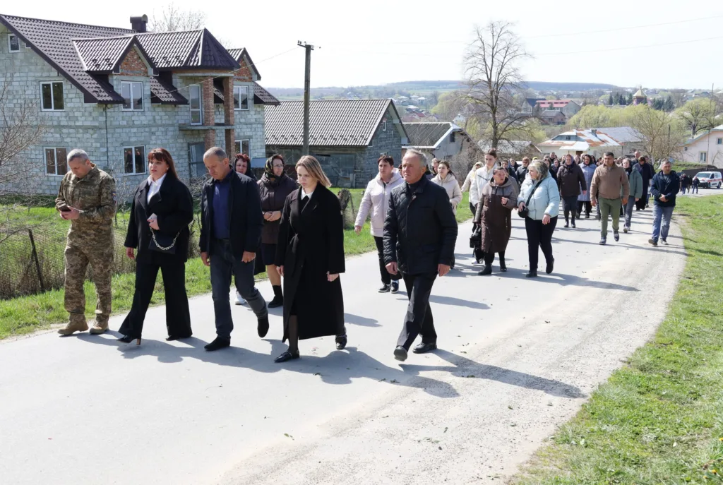 Люди йдуть по сільській дорозі весняного дня