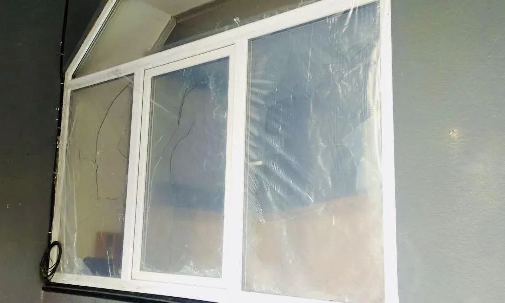 Розбите пластикове вікно із тріщинами на склі