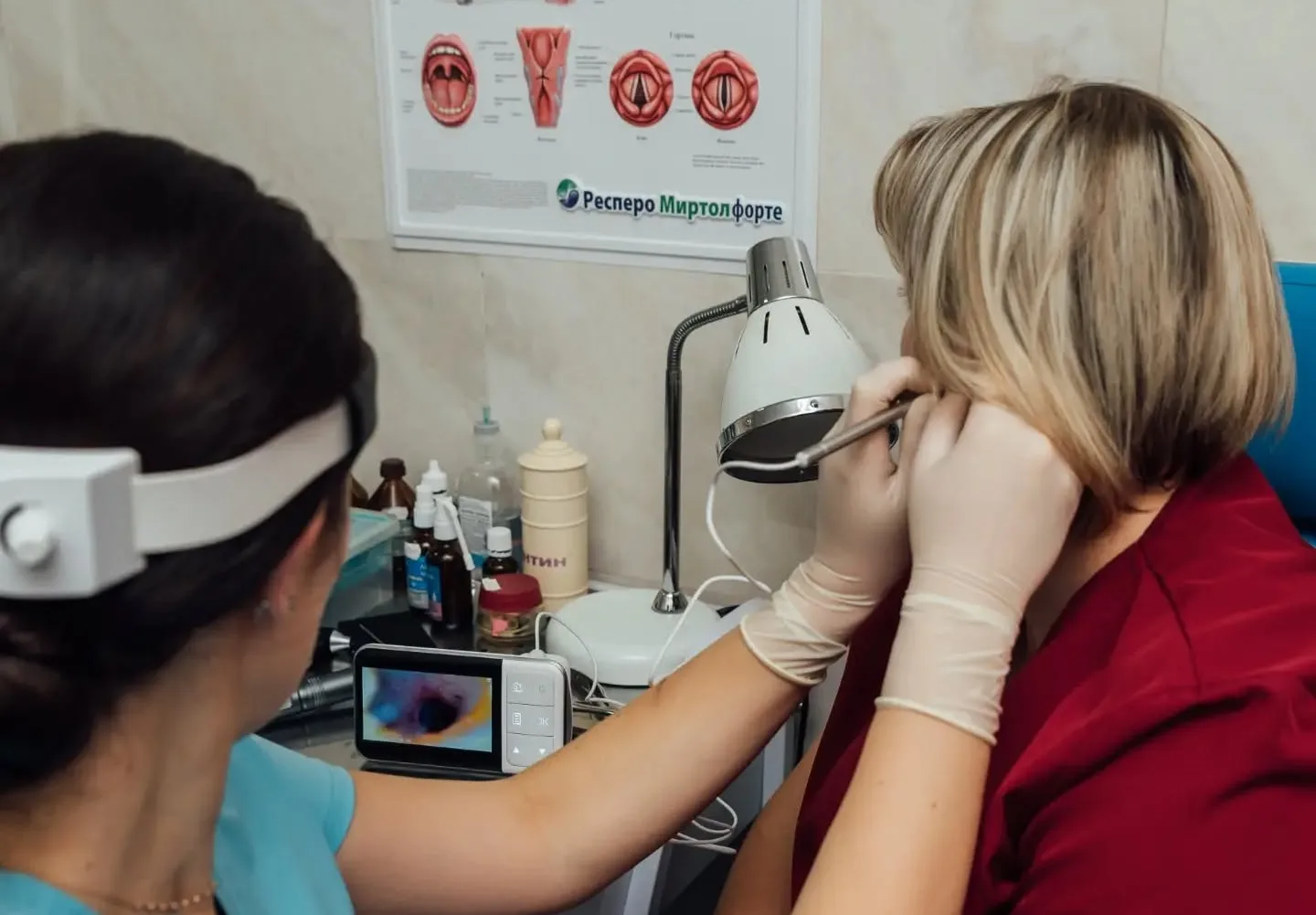 Лікар оглядає вухо пацієнтки отоскопом