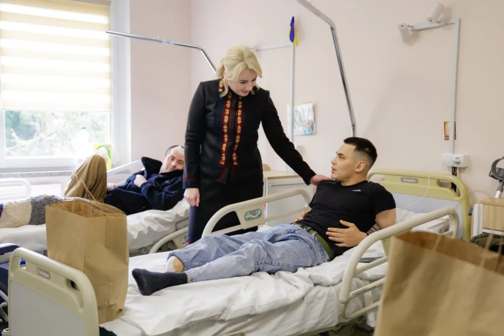 Жінка відвідує поранених військових у лікарні